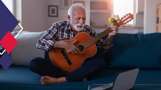 Aproveitar a aposentadoria Foto mostra um senhor sentado em um sofá, com pernas cruzadas e tocando violão olhando para um computador.