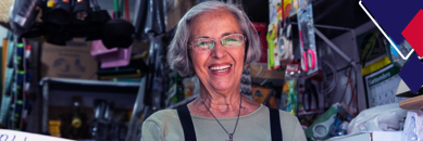 Imagem de mulher de óculos e cabelos brancos que sorri no interior de loja